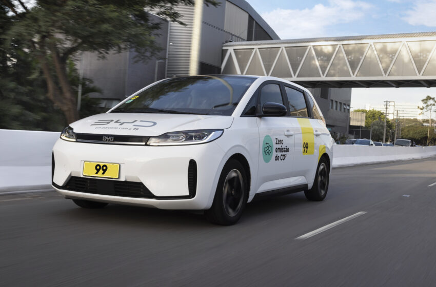 Carro D1 EV com adesivos da 99 e da BYD circula por rua
