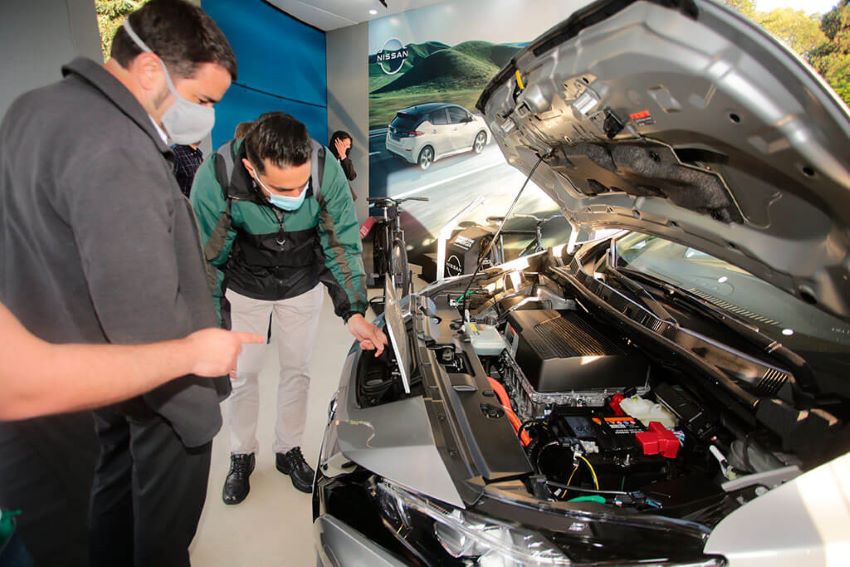 Visitantes observam motor de carro elétrico na edição de 2021