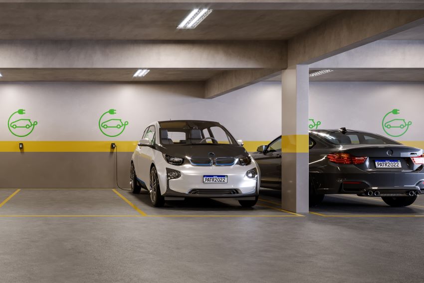 Carro elétrico está conectado a ponto de recarga em estacionamento de condomínio