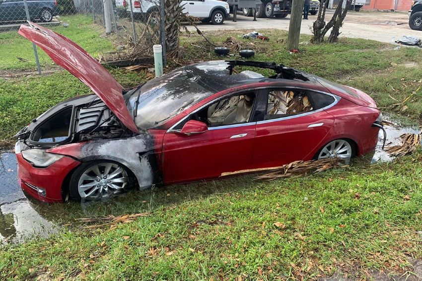 Carro Tesla vermelho tem marcas de incêndio na lataria