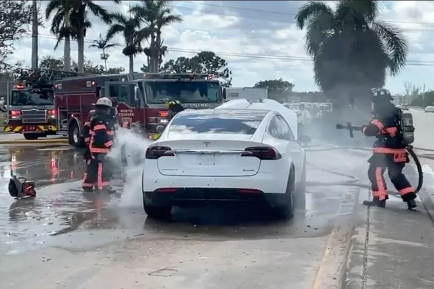 Bombeiros jogam água em carro branco da Tesla para apagar incêndio