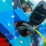 Imagem mostra detalhe de conexão para recarga em carro elétrico azul
