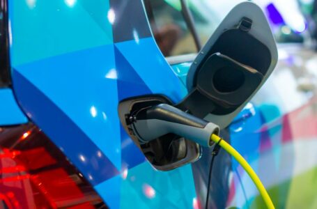 Imagem mostra detalhe de conexão para recarga em carro elétrico azul