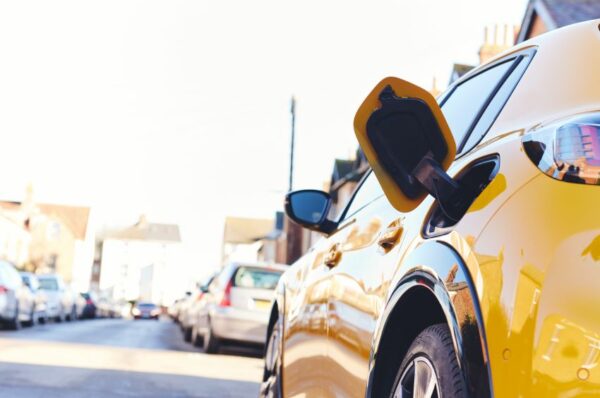 Carro amarelo elétrico com o espaço pra carregar aberto