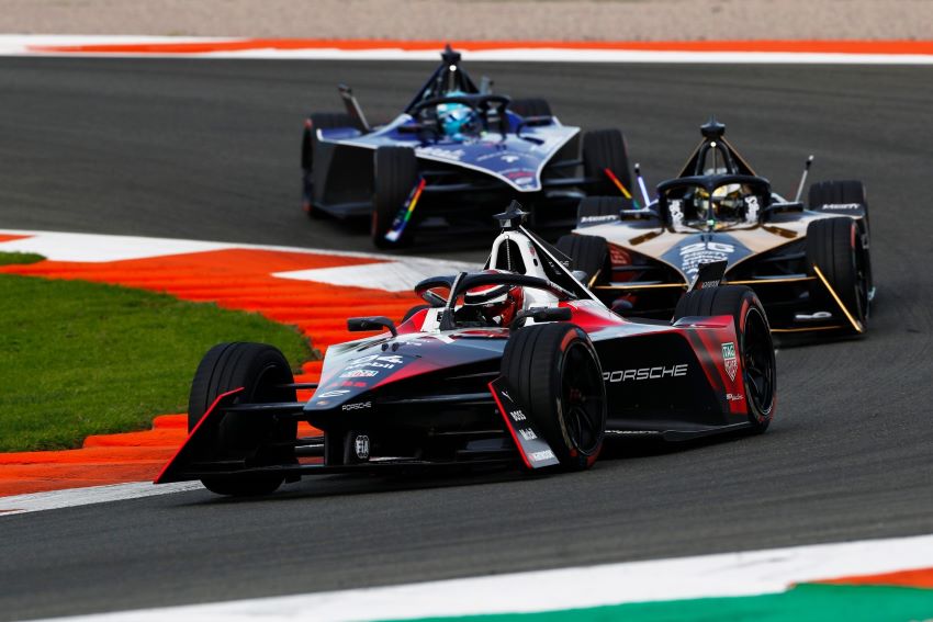 Três carros da Fórmula E em sequência contornam curva para a direita