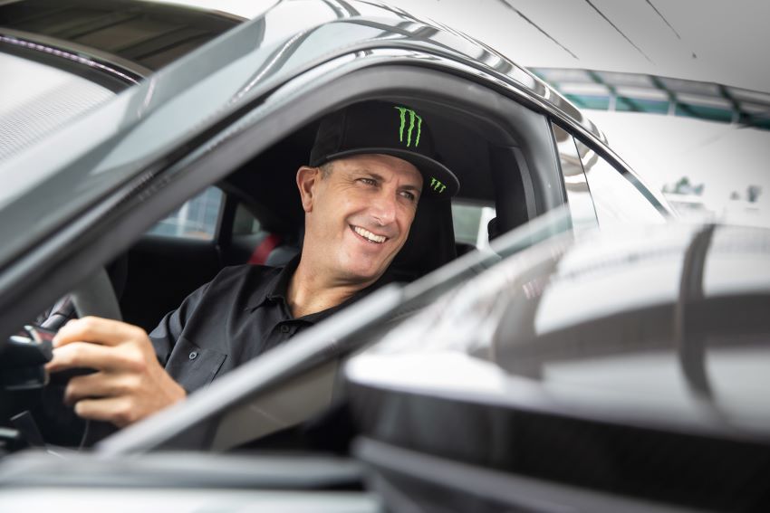 Usando boné na cabeça, piloto Ken Block sorri dentro de Audi