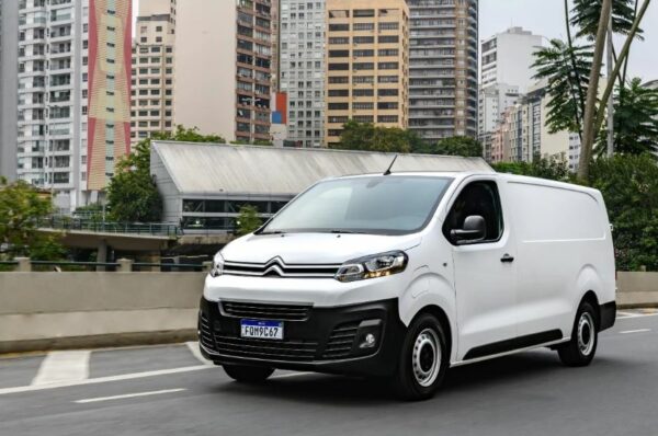 Imagem mostra furgão Citroên e-Jumpy branco em rua com prédios coloridos ao fundo