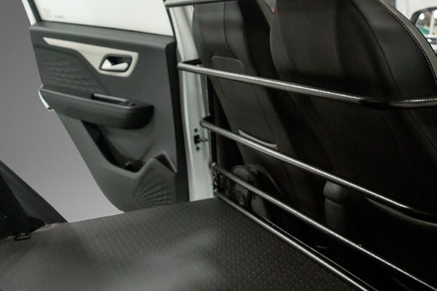 Imagem destaca barras de proteção entre banco de motorista e compartimento de carga