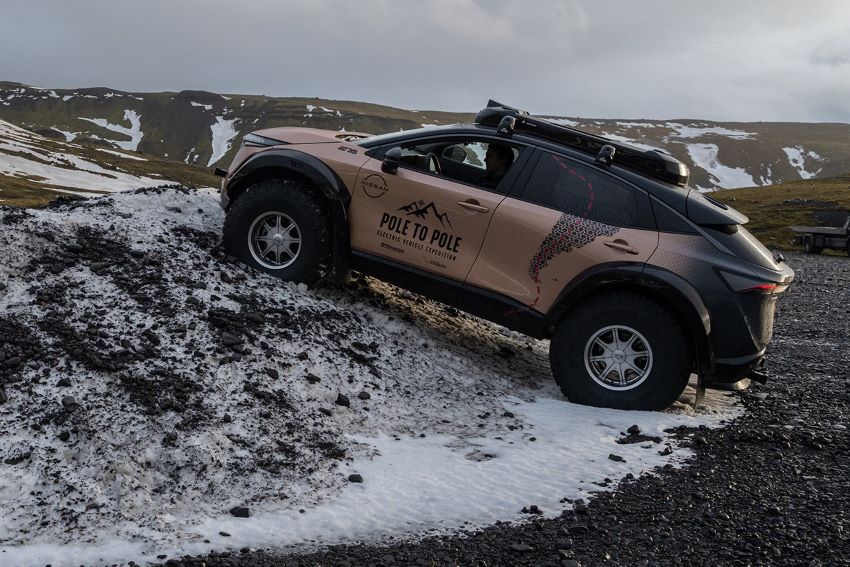 Com rodas de 39 polegadas, Nissan Ariya bege sobre trecho montanhoso na neve