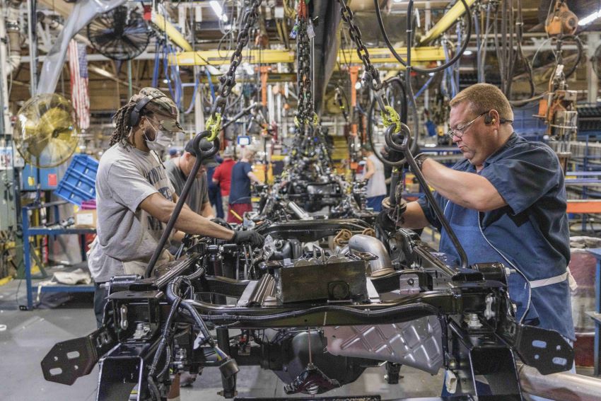 Dois homens trabalham em linha de montagem de veículos da Ford nos Estados Unidos