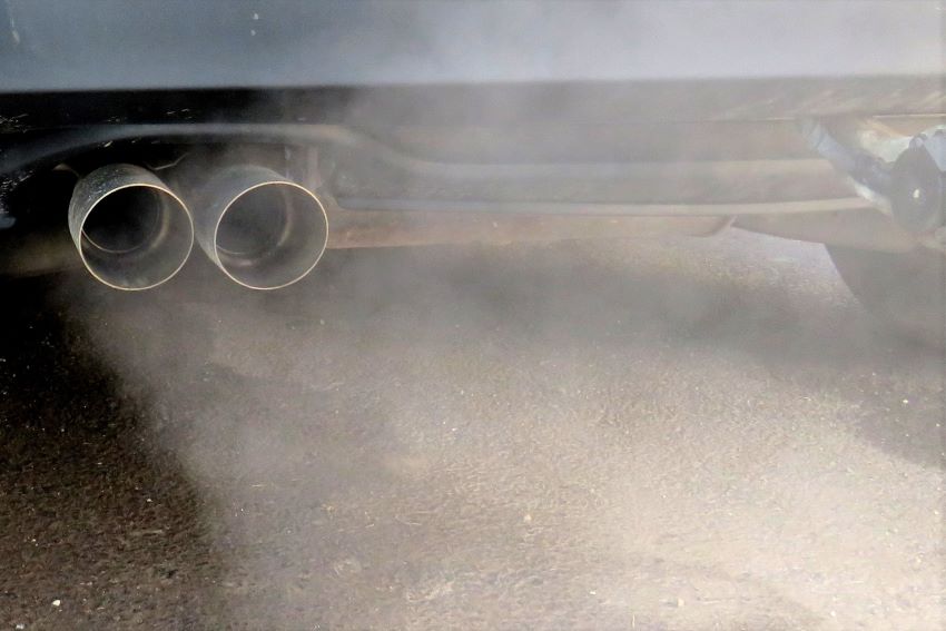Fumaça densa sai de escapamento de carro movido a combustão