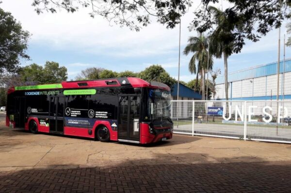 Ônibus elétrico estacionado em frente à placa da Unesp