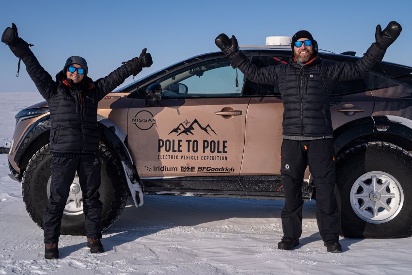 Casal posa para foto em frente a Nissan Ariya da expedição Pole to Pole
