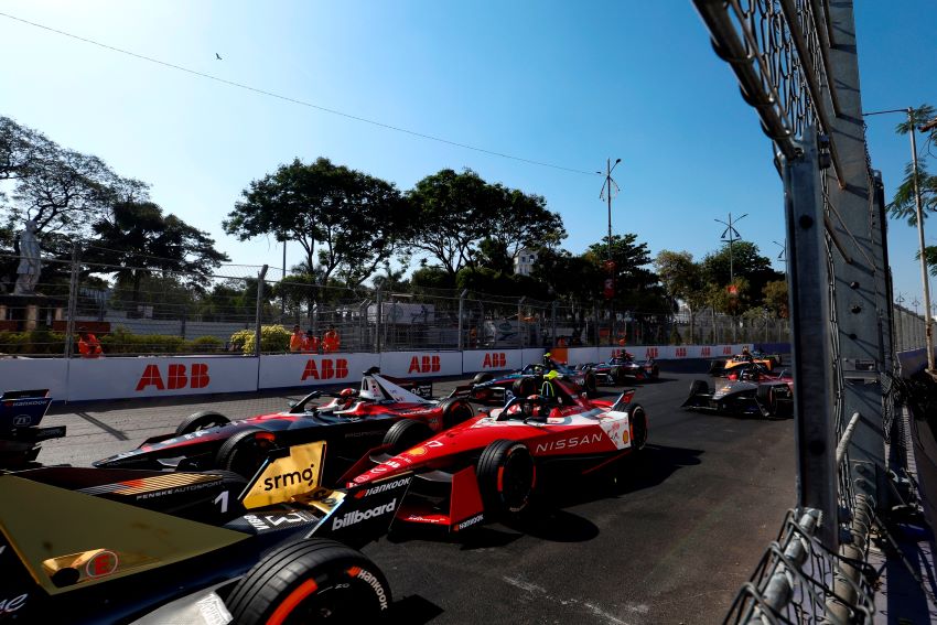 Disputa por posição no grid da Fórmula E, no centro da foto um carro vermelho disputa posição com um preto