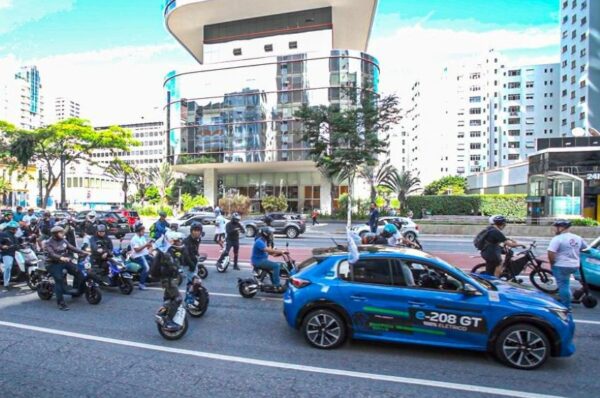 Carreata no Dia da Mobilidade Elétrica, com um carro azul acompanhado de motos e bicicletas elétricas