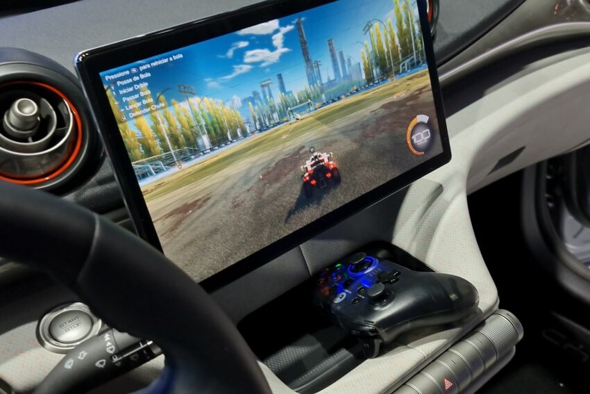 Imagem mostra tela de entretenimento com videogame e controle embaixo