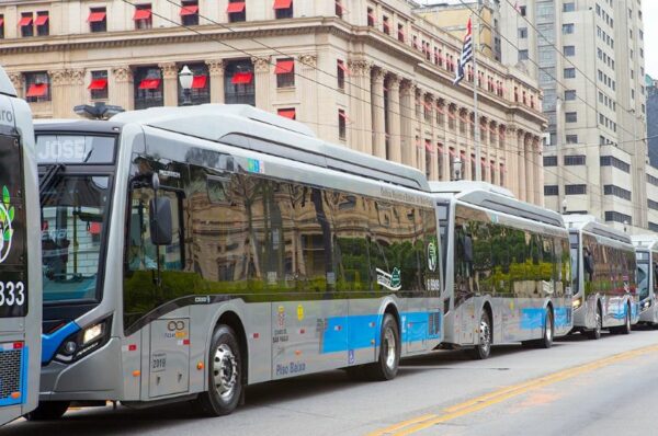 Frota de ônibus elétricos cinza estacionados na cidade de São Paulo