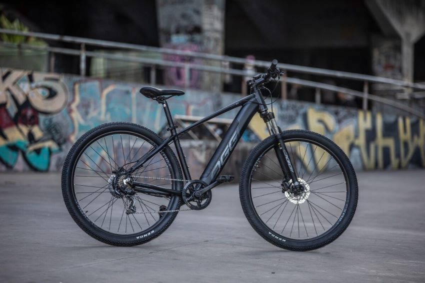 Bicicleta cinza parada com um fundo grafitado