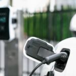 Carro elétrico branco sendo recarregado