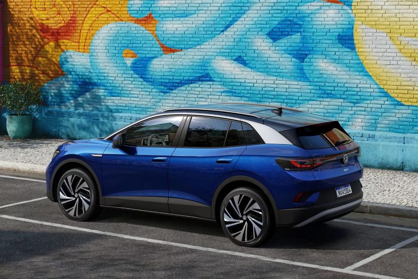 Carro azul estacionado em frente a parede com grafite