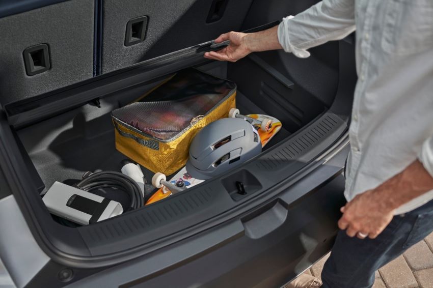 Imagem mostra objetos dentro de porta-malas de carro elétrico, incluindo um carregador portátil