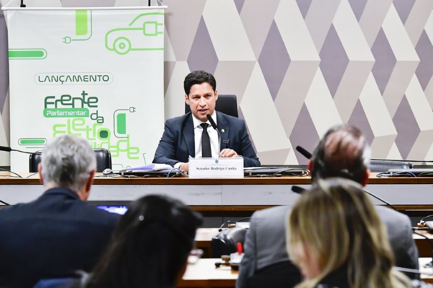 Senador Rodrigo Cunha, sentado na mesa principal, falara para demais parlamentares em reunião da Frente pela Eletromobilidade no Senado