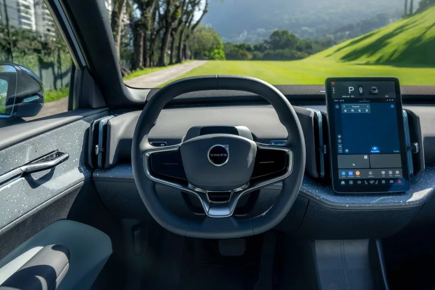 Visão interna da cabine do Volvo EX30, com destaque para o volante e tela de entretenimento