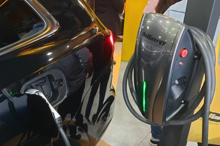 Carregador para carros elétricos BelCharger é visto em funcionamento ao lado de carro elétrico preto