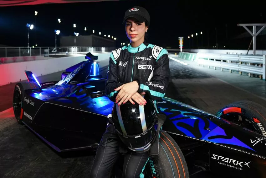 Piloto Reem Al Aboud é uma mulher e está sentada sobre o carro da Fórmula E