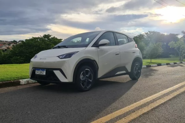 BYD Dolphin Mini branco é visto estacionado em rua com sol brilhando no fundo