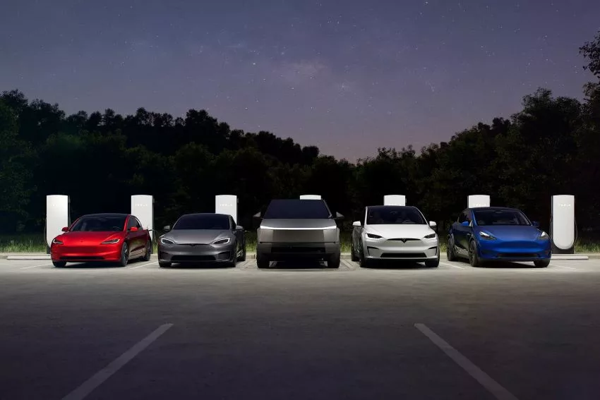 Toda linha de carros da Tesla em frente aos carregadores, também da Tesla