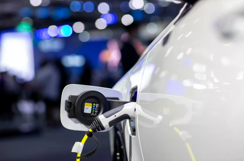 Veículo elétrico branco sendo recarregado