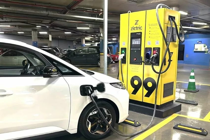 Carro elétrico recebe recarga em eletroposto com o logotipo da 99