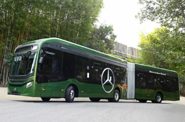 Imagem mostra visão lateral de ônibus articulado pintado de verde