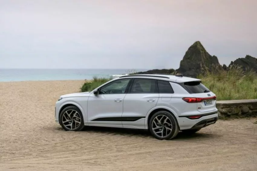 Audi Q6 e-tron branco estacionado em frente a uma praia