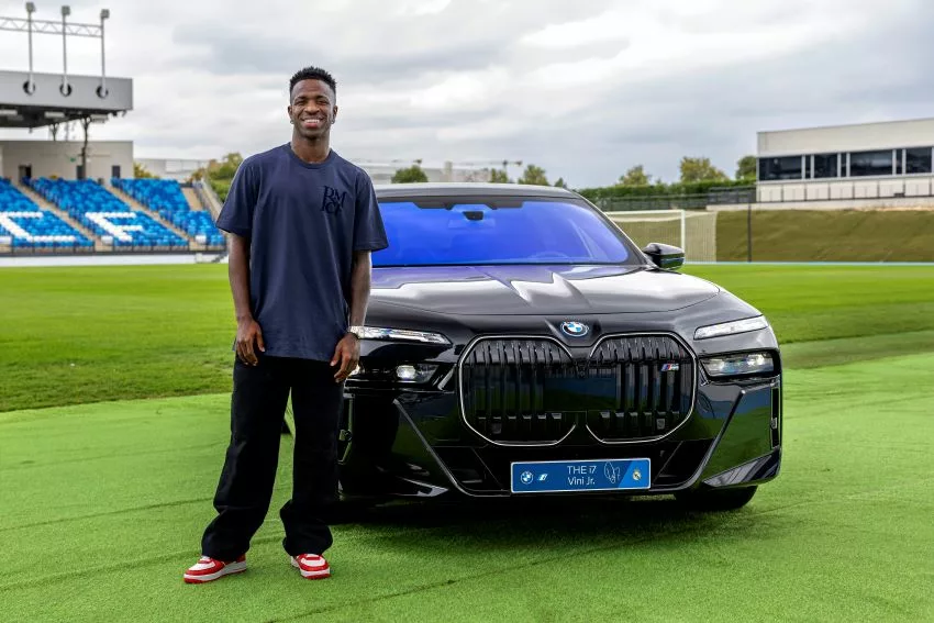 vini jr em pé ao lado do carro da BMW