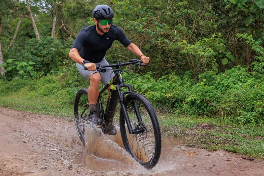 Ciclista passa com bike elétrica por poça de lama