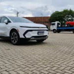 Chevrolet Equinox EV posa estacionado para foto com Opala em cima de caminhão guincho ao fundo