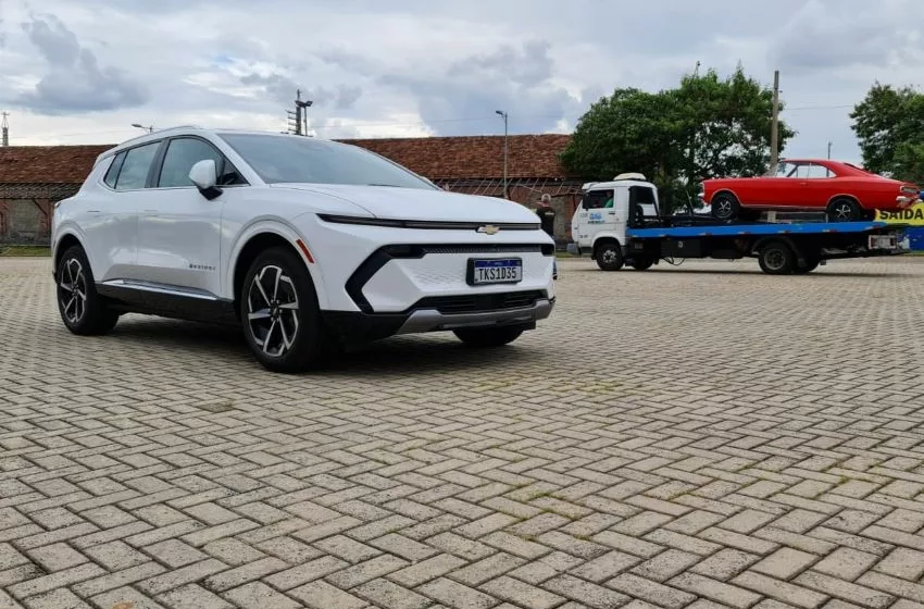 Chevrolet Equinox EV posa estacionado para foto com Opala em cima de caminhão guincho ao fundo