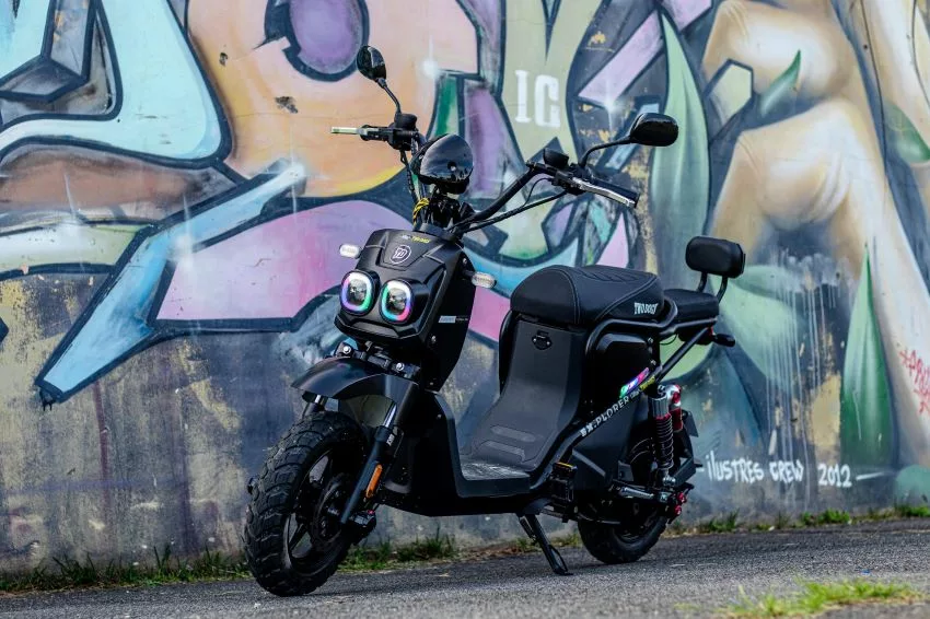 Bike elétrica estacionada em frente à parede com grafitti