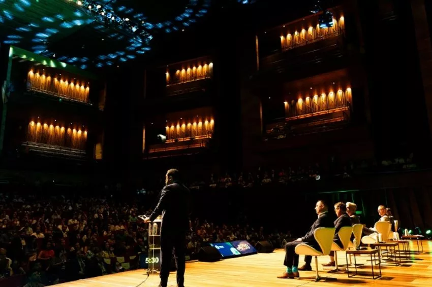 Palestrantes falam para plateia durante evento