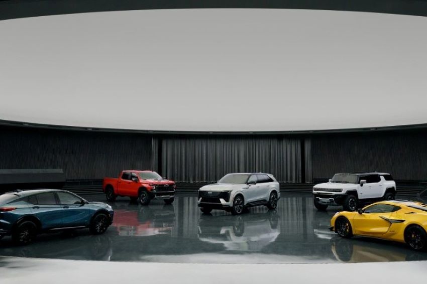 Cinco modelos de carros da General Motors expostos em um salão.
