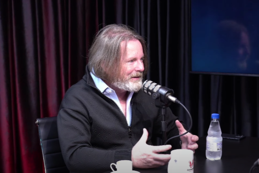 Na imagem, Flávio Figueiredo Assis em frente ao microfone, em uma entrevista ao Podcast Conexão VE