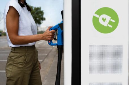 Mulher se aproxima de estação de recarga de veículos elétricos
