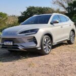 BYD Song Plus estacionado em chão de pedriscos, com natureza ao fundo