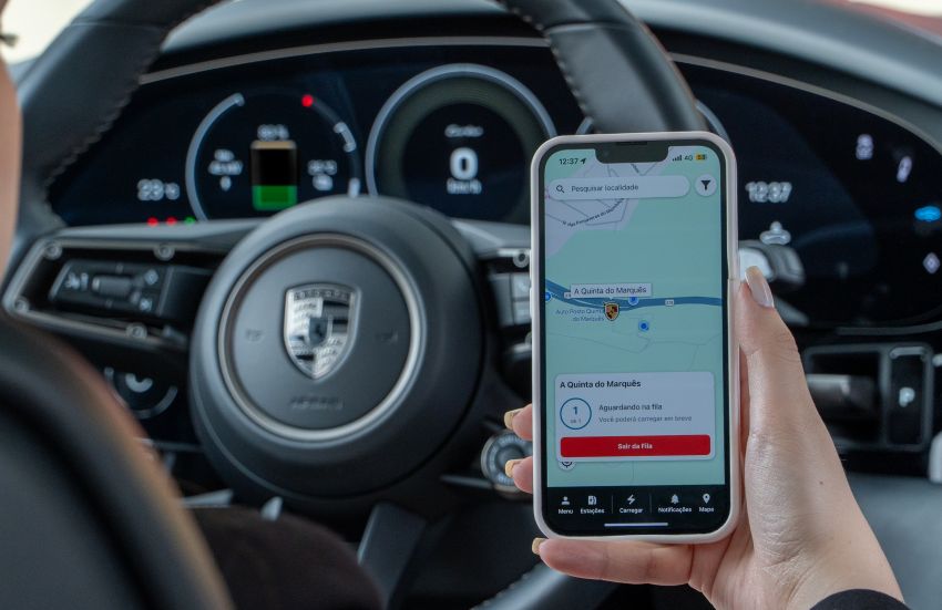 Imagem mostra mão feminina segurando smartphone com app da Porsche dentro de carro