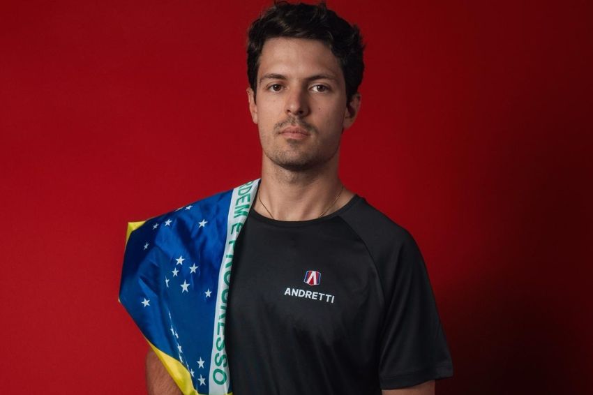Piloto Felipe Drugovich posa com camisa da Andretti e bandeira do Brasil no ombro direito