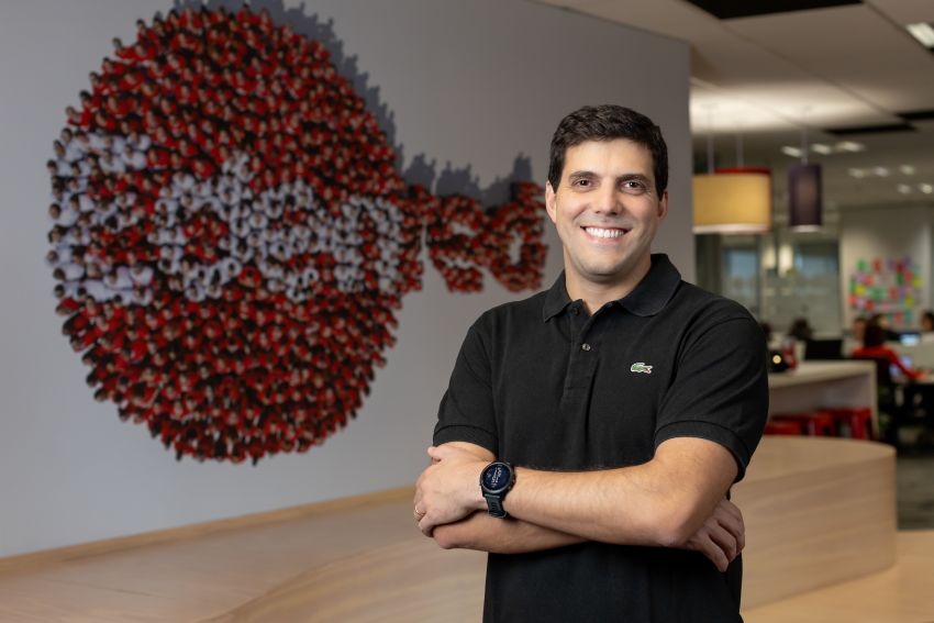 Bruno Barbosa posa para foto em frente a logo da Edenred