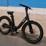 Bike elétrica amparada em parede azul e cinza