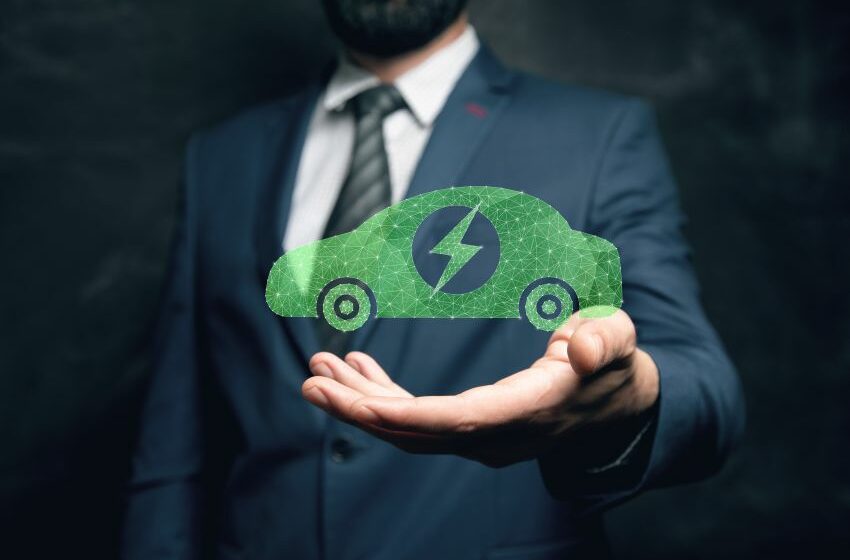 Imagem mostra homem de terno apoiando holográfico de carro elétrico